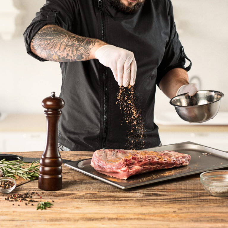 Man cooking meat steak on kitchen